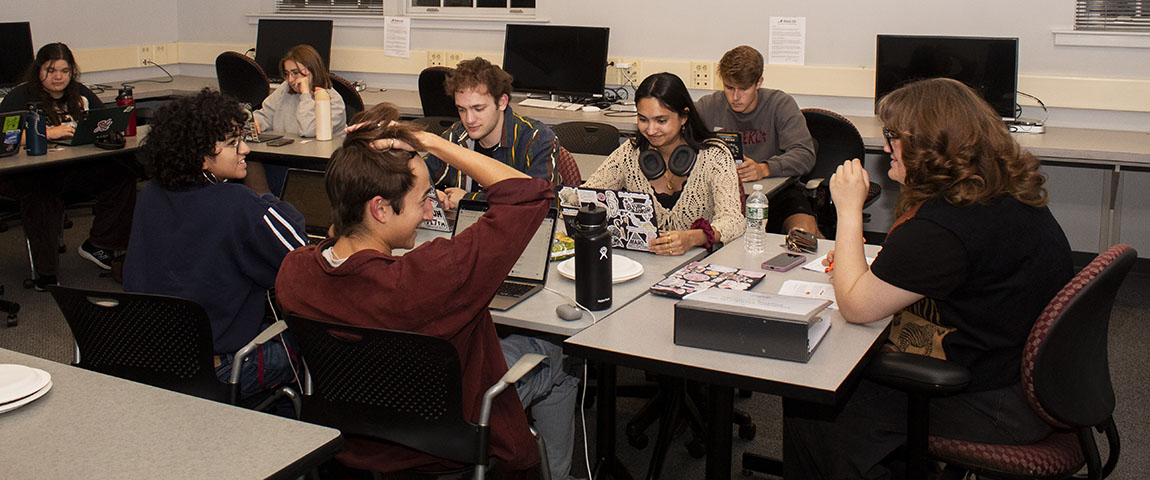 College students sit around computers and work on the student newspaper